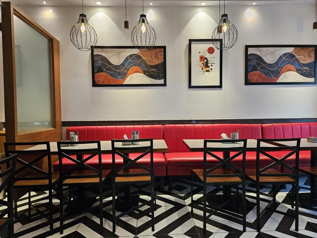 Tizzle dining room with red booths and art wall